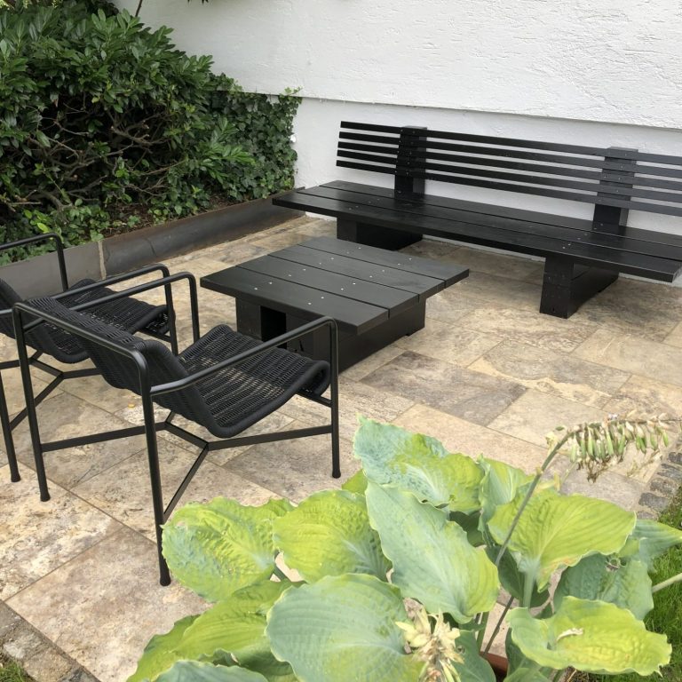 Das Outdoor Lounge Modell KYOTO in schwarz auf einer Terrasse aus Silbertravertin. Daneben der Tisch KYOTO und Stühle von HAY. Das Outdoor Lounge Modell KYOTO in schwarz auf einer Terrasse aus Silbertravertin.